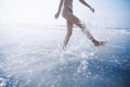 Woman splashing water while walking on beach Royalty Free Stock Photo