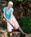 The woman with a splitting axe prepares firewood.Portrait in a sunny day Royalty Free Stock Photo