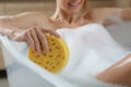 Woman with sponge taking bubble bath, closeup Royalty Free Stock Photo