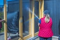 Woman spooling windows with water before washing them.