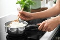 Woman with spoon stirring rice in saucepan, closeup Royalty Free Stock Photo