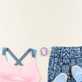 Woman sport bra, leggins, sneakers, headphones and fitness tracker on neutral background. Sport fashion concept. Royalty Free Stock Photo