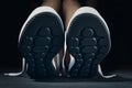 Woman in sport shoes sits on floor in gym, close up. Fitness athlete ready for exercise Royalty Free Stock Photo