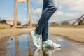 Woman in sport shoes standing in a puddle Royalty Free Stock Photo