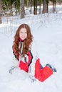 Woman in a sporting suit sits on to snow in-field