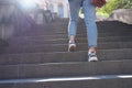 Woman in sportswear climbs up stairs closeup