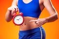 Woman in sportswear holding alarm clock. People, fitness and healthcare concept Royalty Free Stock Photo