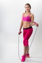 Woman in sportswear holding a rope in his hands. White background. Studio.