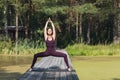 Woman in sportswear practicing yoga, performing Utkata Konasana, goddess pose, exercising outdoors in the park on a sunny morning Royalty Free Stock Photo