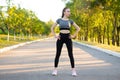 Woman in sportswear standing on the running road in the park.