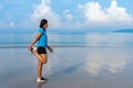 Woman in sportswear streching and preparing to run at the beach with blue sea and beautiful sky background Royalty Free Stock Photo