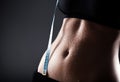 Woman sporty belly after exercise with measuring tape Royalty Free Stock Photo