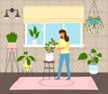 Green home garden or greenhouse with plants in pots, growing houseplants, woman spraying plant