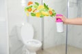 Woman spraying air freshener in bathroom. Citrusy and minty aroma