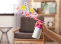 Woman spraying air freshener at home. Flowered aroma