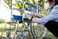 Woman is spraying alcohol and wiping the dirt and dust,disinfectant spray on wheelchair at nursing home,prevention of contagious