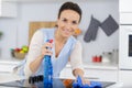 woman spraying houshold cleaner on kitchen counters