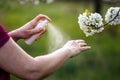 Woman spraying mosquito repellant on her arms