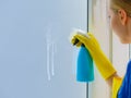 Woman spraying window cleaning detergent