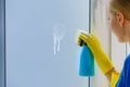 Woman spraying window cleaning detergent