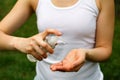 A woman sprays antiseptic on her hands - taking care of health, cleanliness, protection from dangerous bacteria and viruses.