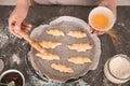 Woman spreading egg yolk on croissants