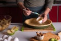 Woman spreading eggs on the dough with a cooking brush in a bakery dish, apple pie making