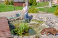 Woman in the spring cleans the artificial pond Royalty Free Stock Photo