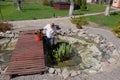 A woman in the spring cleans an artificial pond Royalty Free Stock Photo