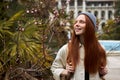 Woman in spring garden. Trendy female enjoy feeling smell of blooming flowers on tree