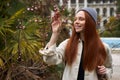 Woman in spring garden. Trendy female enjoy feeling smell of blooming flowers on tree