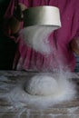 The woman sprinkles the dough from the satiated for the flour, the vocifa bursts and the falling flour. Preparatory process for