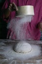 The woman sprinkles the dough from the satiated for the flour, the vocifa bursts and the falling flour. Preparatory process for