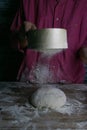 The woman sprinkles the dough from the satiated for the flour, the vocifa bursts and the falling flour. Preparatory process for