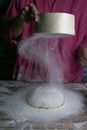 The woman sprinkles the dough from the satiated for the flour, the vocifa bursts and the falling flour. Preparatory process for