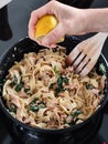 Woman squeeze a lemon on tasty home made seafood pasta in home kitchen, Closeup shot