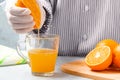 Woman squeezes orange juice in a glass cup