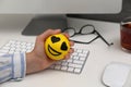 Woman squeezing antistress ball at workplace, closeup