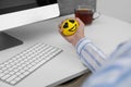 Woman squeezing antistress ball at workplace, closeup