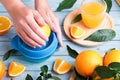 Woman squeezing fresh orange juice on blue table, top view Royalty Free Stock Photo