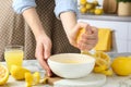 Woman squeezing lemon juice into bowl at marble table, closeup Royalty Free Stock Photo