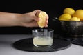 Woman squeezing lemon juice into glass bowl at table, closeup Royalty Free Stock Photo