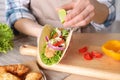 Woman squeezing lime on fish taco at table