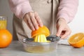 Woman squeezing orange juice at grey table, closeup Royalty Free Stock Photo