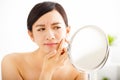 woman Squeezing pimple looking on mirror Royalty Free Stock Photo