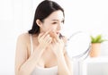 woman squeezing pimples in front of mirror Royalty Free Stock Photo