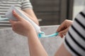 Woman squeezing toothpaste from tube onto toothbrush near mirror in bathroom, closeup Royalty Free Stock Photo