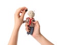 Woman stabbing voodoo doll dressed as businessman with pin on white background, closeup