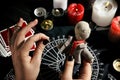 Woman stabbing voodoo doll with needle at table, closeup. Curse ceremony