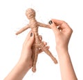 Woman stabbing voodoo doll with pin on white background, closeup